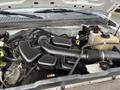 The engine compartment of a 2010 Ford F-250 SD featuring a large black air intake and various engine components with yellow and black caps