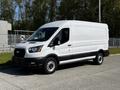 A 2022 Ford Transit van in white with a black lower front bumper and black wheels parked on a pavement