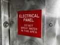 Red electrical panel sign indicating do not spray water in this area