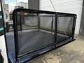 A 2022 Heartland Torque with a black mesh enclosure in the foreground designed for securing cargo on a trailer
