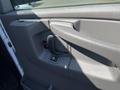 Interior door panel of a 2012 Chevrolet Express featuring a door handle and power window controls