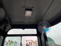 Interior view of a mini excavator featuring a ceiling light and a small fan mounted on the side window