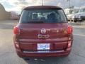 A red 2015 Fiat 500L viewed from the rear showing the logo and model name on the back with visible brake lights and license plate