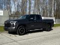 2023 Toyota Tundra pickup truck in a dark gray color with black wheels and a modern design parked on a concrete surface