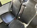 Two black leather seats with seatbelts in a vehicle interior