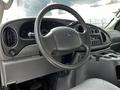 Interior view of a 2004 Ford Econoline showcasing the steering wheel dashboard and radio controls