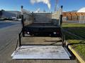 A 2014 Mitsubishi Fuso FE truck with a flatbed and a foldable loading ramp in the lowered position