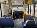 Interior view of a 2018 Chevrolet Express showing the driver's seat dashboard and passenger seats with yellow handrails