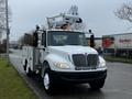 A white 2013 International DuraStar truck with a bucket lift mounted on top offering utility services