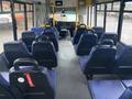 Interior of a 2018 Chevrolet Express with blue seats arranged in rows and a driver area visible at the front