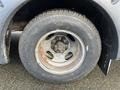 Close-up of a 2017 Chevrolet Express wheel featuring a steel rim and a weathered tire showing signs of wear