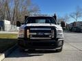 A 2011 Ford F-350 SD truck facing forward with a black grille and chrome accents headlights and a push bar attached to the front