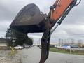 A 2006 Hitachi ZX200LC excavator with a large metal bucket extended upward showing details of the hydraulic arm and attachment