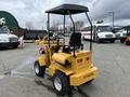 A yellow 2024 AGT Industrial KRW23 Mini Loader with a raised operator's seat and a front loader attachment on large wheels