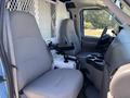 Interior of a 2008 Ford E-350 showing two gray bucket seats and a central console with cup holders and a control panel