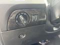 A control panel featuring a dial for headlights with settings including auto and off along with buttons for various functions in a 2015 Dodge Durango