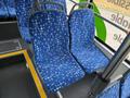 Two blue bus seats with a pattern of white speckles and lines inside a vehicle interior