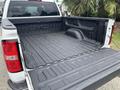 A 2016 GMC Sierra 1500 with an open truck bed featuring a durable bed liner and the GMC logo embossed in the interior side of the truck bed