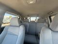 Interior view of a 2010 Toyota Tacoma showing two front seats and a spacious rear seat with fabric upholstery and seat belts