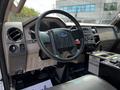 The interior of a 2009 Ford F-550 featuring a steering wheel dashboard and control panel with various buttons and dials