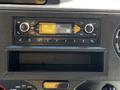 Dashboard console of a 2021 Ford Econoline featuring a radio display with buttons and a digital clock