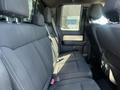Interior view of the backseat of a 2014 Ford F-150 featuring black fabric seats with seatbelts and visible headrests