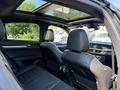The interior of a 2020 Alfa Romeo Stelvio showing two black leather front seats and a sunroof above