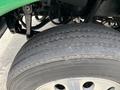 Close-up of a 2013 Kenworth T370 tire showing tread pattern and details of the wheel rim and suspension components