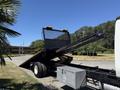 A 2018 International DuraStar tow truck with a raised flatbed and ramps extended for loading vehicles