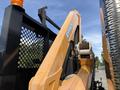Close-up of an orange arm of a 2011 International 4300 truck with a winch and a metal spool attached to it