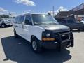 A 2012 Chevrolet Express van with a black front hood and a front grill guard parked in a lot