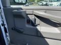 The door panel of a 2009 Chevrolet Express featuring a window control switch and a door handle