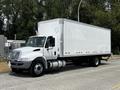 A 2019 International 4300 truck with a white cargo box and black wheels parked on a street