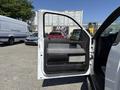 A 2014 Ford F-150 with its driver's side door open showcasing the interior features like the door panel and controls