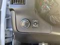 Close-up of the dashboard controls in a 2021 Chevrolet Express featuring an automatic light control knob and a button to turn off the dome lights