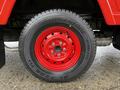 Red wheel of a 2001 Toyota Dyna featuring a Bridgestone tire with visible tread and five wheel nuts