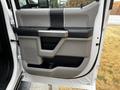 The image shows the interior door panel of a 2020 Ford F-350 featuring a gray and black design with a handle and storage compartments