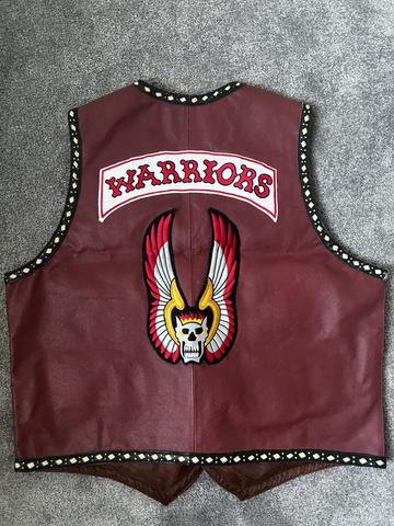 A maroon leather vest featuring the word "WARRIORS" in white with red trim and an emblem of a winged skull with colorful wings