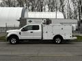 A 2019 Ford F-350 SD pickup truck with a white service body and multiple compartments for tools and equipment