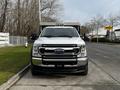 A white 2021 Ford F-550 truck facing forward with a shiny chrome grille and headlights