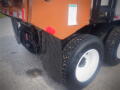 A 2016 International WorkStar 7500 truck with large black tires and a distinctive orange rear body featuring a chain and red lights