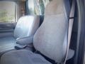 Two front seats of a 2006 Ford F-650 with grey fabric upholstery and seat belts