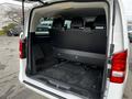 The rear cargo space of a 2018 Mercedes-Benz Metris with foldable seats and a black carpeted floor