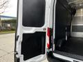 The image shows the side door of a 2020 Ford Transit van opened to reveal a spacious interior with black flooring and paneling