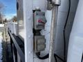 A control panel mounted on the side of a truck featuring several switches and a valve with a red handle