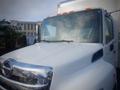 A white 2013 Hino 308 truck with a shiny chrome grille and slightly foggy windshield