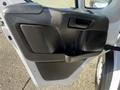 The interior side of a 2021 RAM Promaster door showing a black plastic armrest and a storage compartment