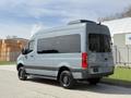 A 2019 Mercedes-Benz Sprinter van in a gray color with black wheels parked at an angle showcasing its rear and side profile