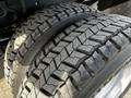 Close-up of two large, rugged tires with deep treads from a 2011 Ford F-450 SD showcasing their durable design and robust grip for heavy-duty performance