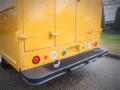 A yellow 2008 Freightliner MT45 Chassis with a flat rear bumper featuring red and white lights and a textured surface